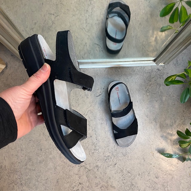 Stötdämpande svart sandal med avtagbar sula.